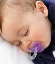 نوزادی خوابیده با پستانک در دهانش