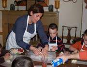 the woman helping children in cooking