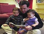 father reading books to his children