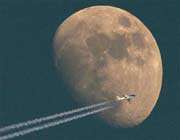 a jet flies past the moon over switzerland on april 24, 2010.