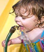 baby drinking from a water hose