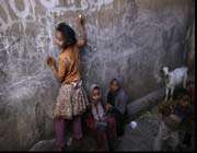 a yemeni girl writes on a wall as she and other children play in an alley of the old city of sana’a. 