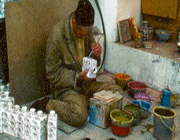 un artisan peint les émaux sur une pièce cuite