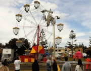 people look at a cheetah s200 airplane stuck in a ferris wheel after it crashed into the fairground near taree, australia. 