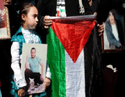 a palestinian child holds a picture of a relative jailed in israel on october 14, 2011.