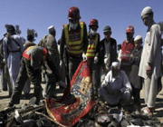 people inspect the scene of an attack in pakistan. 