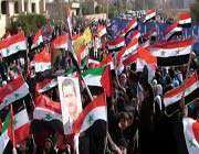 syrian demonstrators waving syrian and palestinian flags during a pro-government rally in the eastern city of deir zor, january 20, 2012.