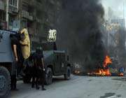 egyptian security forces stand guard in front of a blaze in cairo