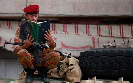 سربازی در حال تلاوت قرآن