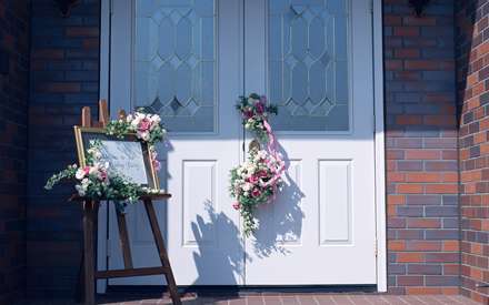 دسته گل هاي سفيد بر روي و تابلوی خوش آمد در جشن ازدواج