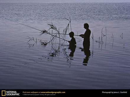يك مرد به همراه پسرش در بركه در حال ماهي گيري