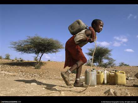 كودك سياه پوست در حال حمل آب