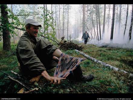 مردی در حال بستن پایش در جنگل