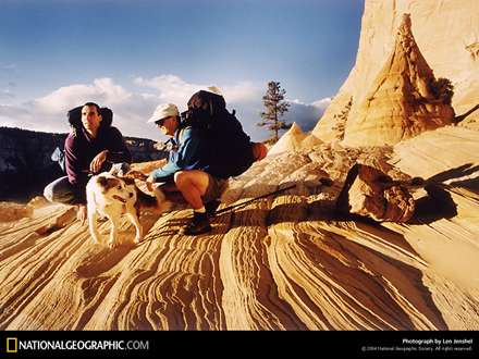 دو كوهنورد با يك سگ در حال صعود