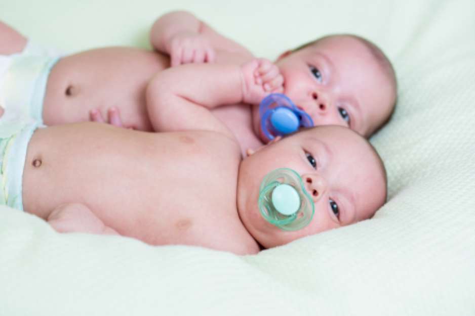 funny newborn baby twins lying one next other