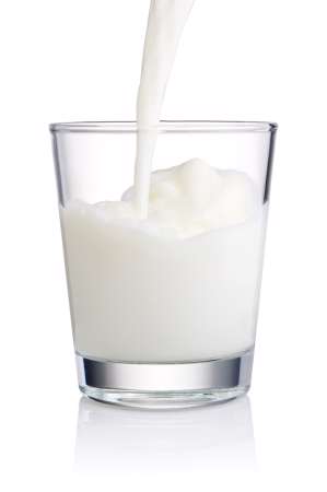 Pouring a Fresh Glass of Milk isolated on white background