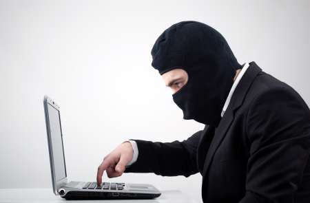 Hacker stealing information from a computer at the desk