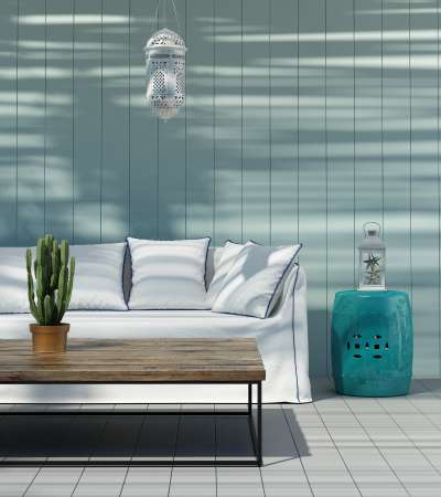 Summer house in Greek island with sofa, stool, lantern and table