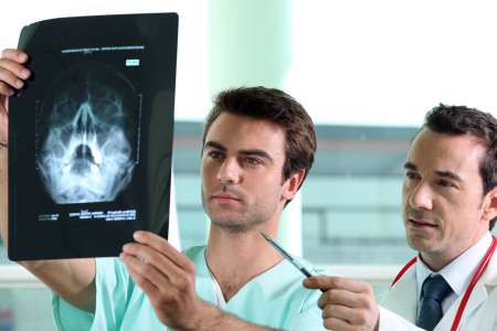 Mأ©decin et infirmier regardant radiographie