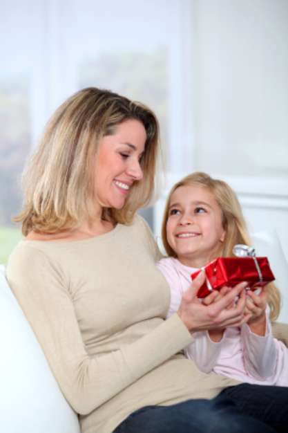 Little girl offering present to her mom