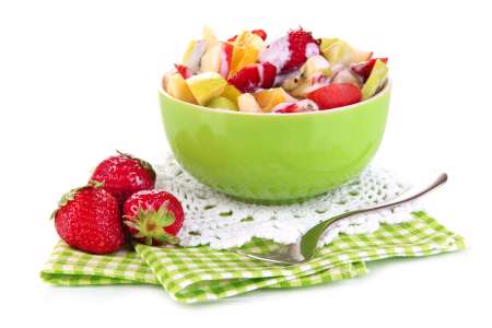 Useful fruit salad of fresh fruits and berries in bowl isolated