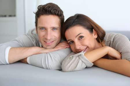 Portrait of sweet couple sitting in sofa