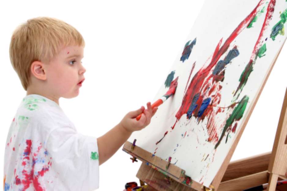 caucasian toddler boy painting at easel