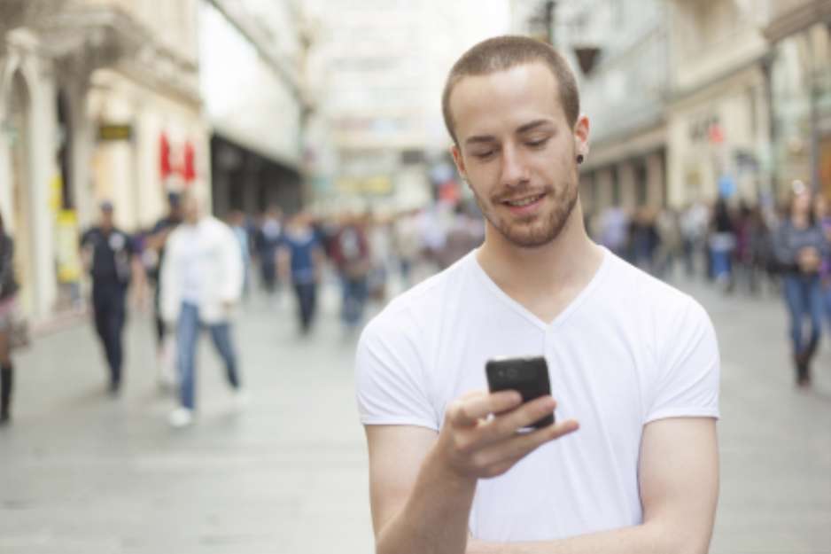 Young Man with cell phone walking