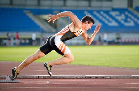 Sprinter leaving starting blocks on the running track. Explosive