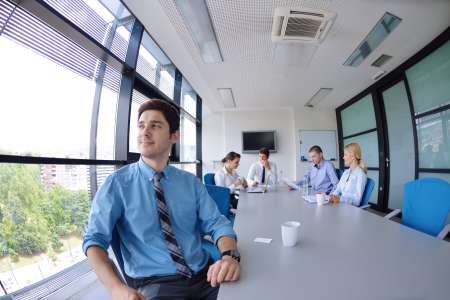 business man  on a meeting in offce with colleagues in backgroun
