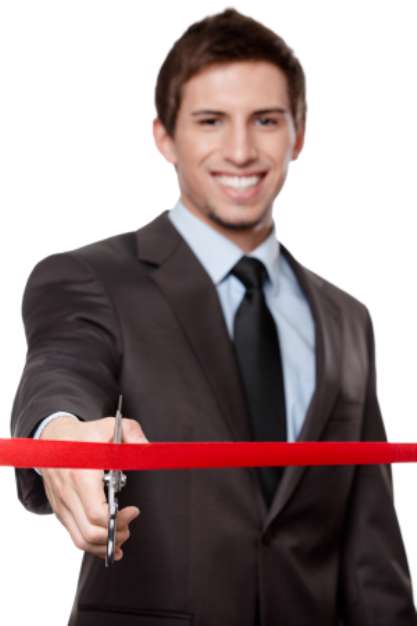 A business man cutting a scarlet satin ribbon with scissors