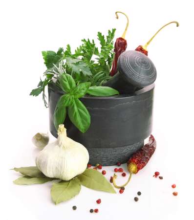 Black stone mortar and pestle with fresh herbs