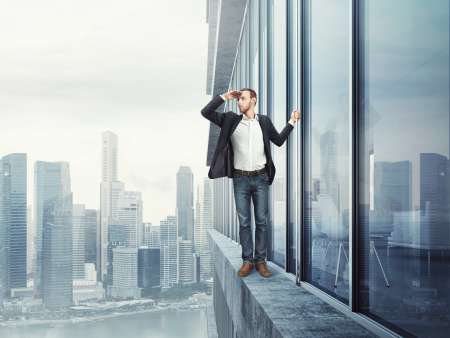 man standing on the edge and looking at the city
