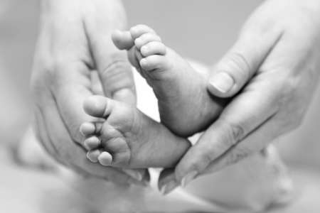 Mother gentle touch - cute baby feet