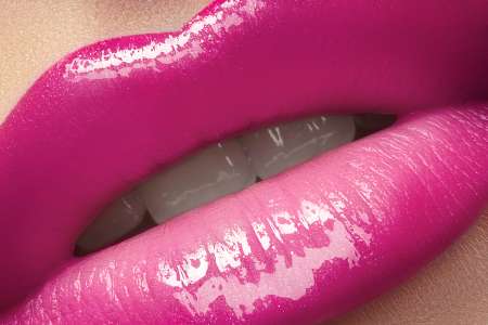 Close-up of lips with bright fashion pink glossy makeup