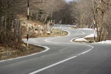 Road winding mountain crosses the wood