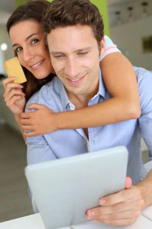 Cheerful couple with tablet shopping on internet
