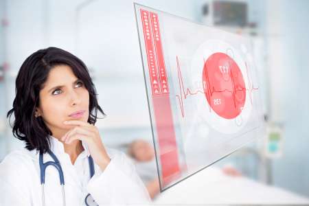 Doctor looking up at screen showing red ECG data