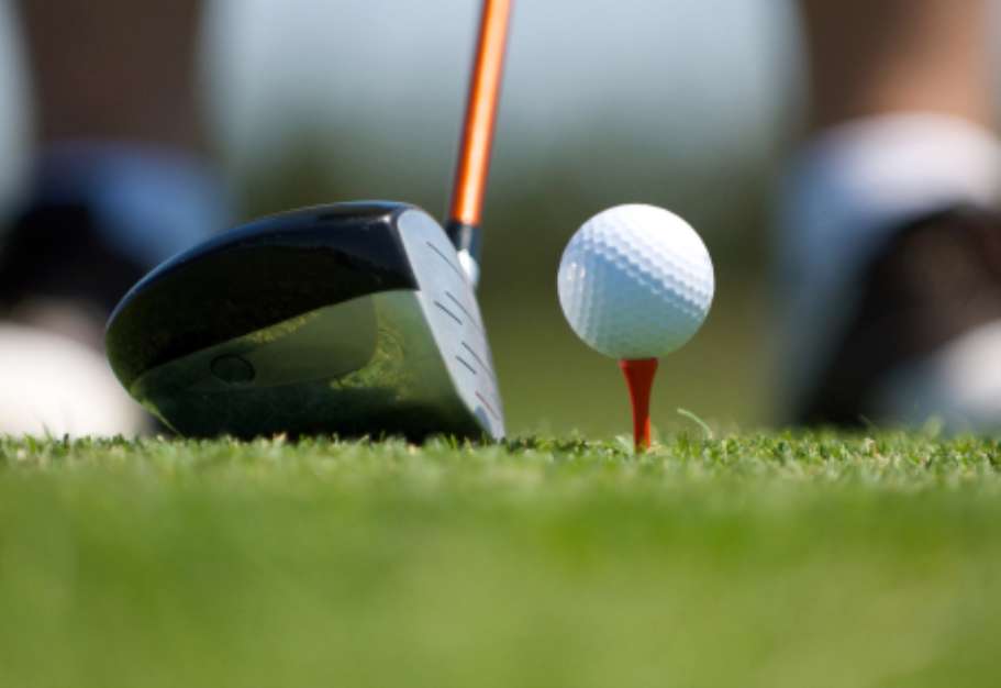 Up close image of a golf ball on tee with club