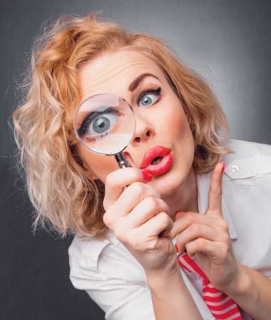 Woman with magnifier, close-up expressive face of a funny woman