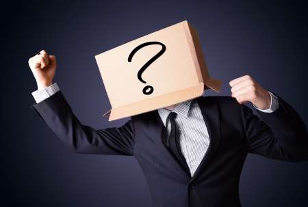 Businessman gesturing with a cardboard box on his head with ques