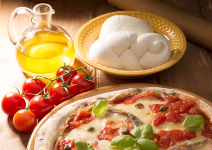 pizza with ingredients on wooden table
