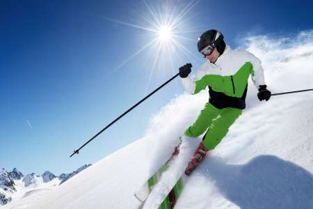 Skier in mountains, prepared piste and sunny day