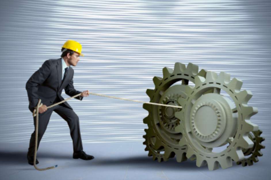 Businessman turning a gear system
