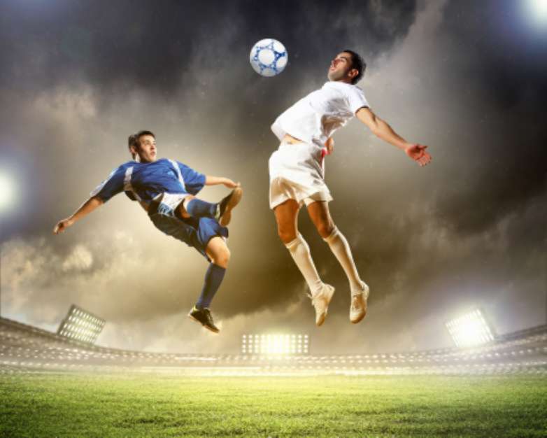 two football players striking the ball