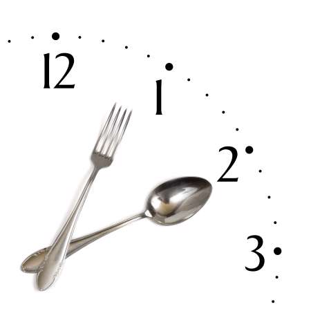 Clock made of spoon and fork, isolated on white background