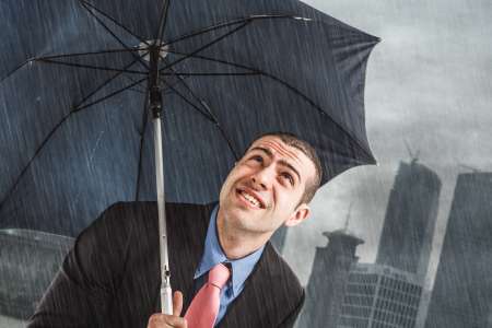 Businessman under heavy rain
