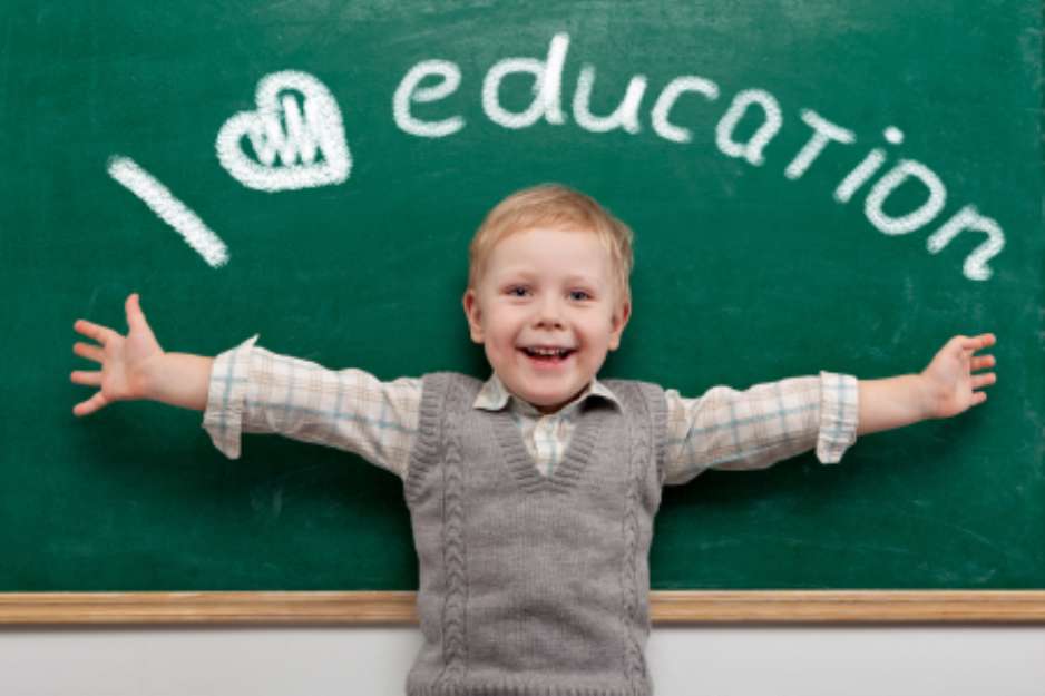 Cheerful smiling child at the blackboard. School concept