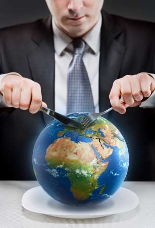 Greedy businessman cutting planet Earth