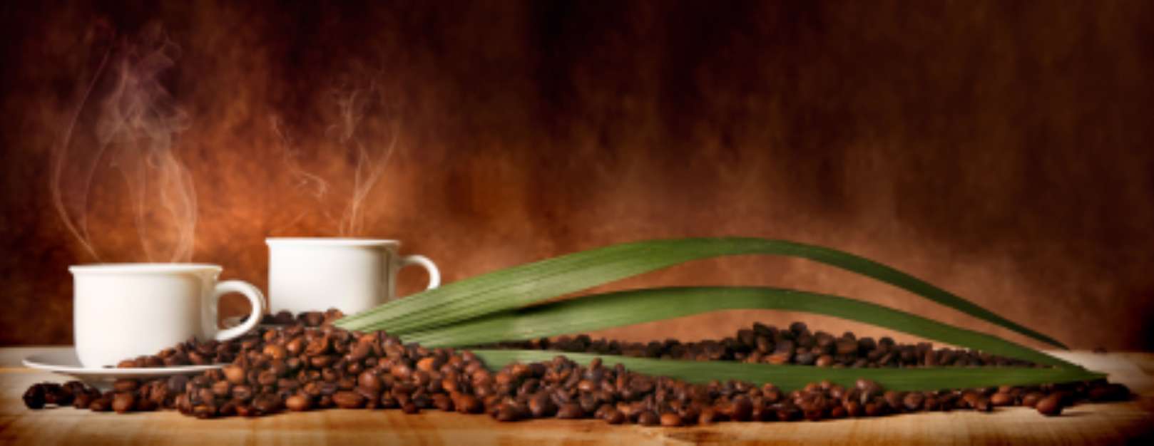 Caffأ¨ in tazza, con chicchi sparsi sulla tavola